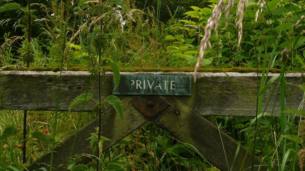 fence amongst greenery with 'private' sign