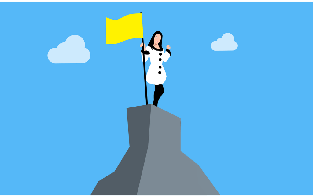 women atop a mountain (self worth success goals)