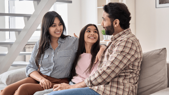 image of a mother, child, and father sat on a sofa